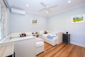 a white bedroom with a bed and a sink at Family-Friendly 2BR Home Near Eastland n BBQ & Toys in Ringwood North
