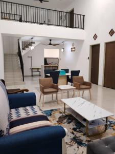 a living room with couches and tables in a room at Homestay Q Haven in Kuantan