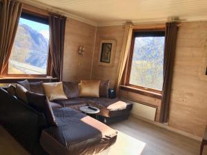 Una sala de estar con un sofá y dos ventanas. en Jølster Lake View, en Årdal