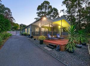 a house with a table and chairs in front of it at Rest & Relax at The Secret Garden Getaway in Harrisons Pocket