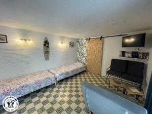a room with two beds and a couch in it at Charmante maison proche plage et forêts - FR-1-426-594 in La Barre-de-Monts