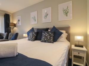 Church LeighにあるThe Lodge at Middleton Houseのベッド(青と白の枕付)