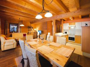 a dining room and living room with a wooden table at Holiday Village Wildschönau Chalet with Terrace in Niederau