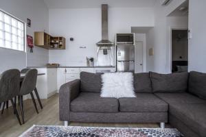 a living room with a couch and a kitchen at Archipelago Apartments Esperance in Esperance