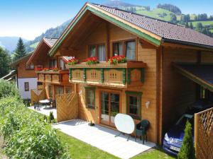 a house with a balcony with flowers on it at Feriendorf Wildschönau near sauna in Niederau