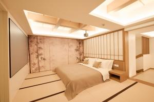 a bedroom with a bed with white sheets and pillows at Qinghai Xisu in Dalian +20 photos