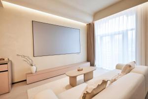 a living room with a white couch and a large window at Qinghai Xisu in Dalian