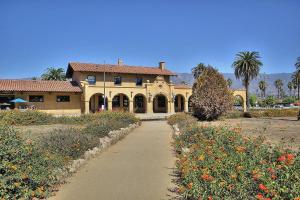 Una casa con un camino frente a un campo de flores. en West Beach Villa 2, en Santa Bárbara