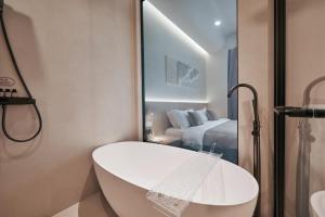 a bathroom with a bath tub and a bedroom at Qinghai Xisu in Dalian