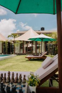 a chess board and a green umbrella next to a building at Wildflower Events in Uluwatu