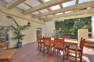un patio con mesa de madera y sillas de madera en West Beach Villa 1, en Santa Bárbara