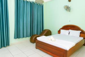 a bedroom with a bed and a chair in it at Thanh Tùng Hotel HCM in Ho Chi Minh City