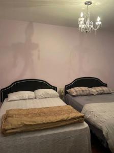 a bedroom with two beds and a chandelier at 2 Beds availabe and self service small breakfast in Montréal