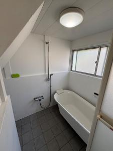 a white bathroom with a tub and a window at Kamakura S house in Yokohama +31 photos