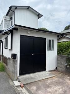 a garage with a black garage door on a house at Kamakura S house in Yokohama
