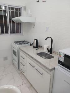 a white kitchen with a sink and a stove at Artin House Mendoza in Ciudad Lujan de Cuyo +11 photos