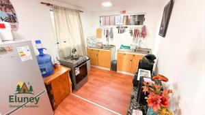 a kitchen with wooden floors and a refrigerator in it at Glamping Eluney Bucalemu in Paredones