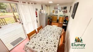 a small kitchen with a table and a refrigerator at Glamping Eluney Bucalemu in Paredones
