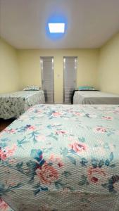 a bedroom with two beds and a bedspread with flowers at Hall dos parques in Belém