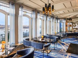 a restaurant with tables and chairs and large windows at Fairmont Le Chateau Frontenac in Quebec City