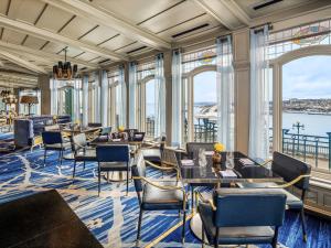 a restaurant with tables and chairs and windows at Fairmont Le Chateau Frontenac in Quebec City