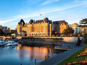 un gran edificio junto a un río con barcos dentro en Fairmont Empress Hotel, en Victoria