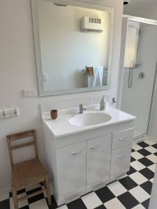 a bathroom with a sink and a mirror and a chair at Lovely Wanaka Crib in Wanaka