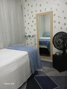 a bedroom with a bed and a mirror at At Suites in Maragogi