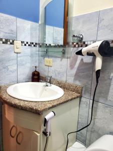 a bathroom with a sink and a blow dryer at In the heart of Vilcabamba House don Tuquito in Vilcabamba