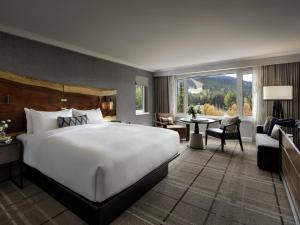 a bedroom with a large bed and a living room at Fairmont Chateau Whistler in Whistler