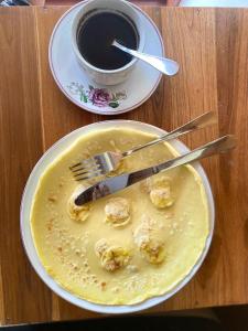 un plato de comida con un tenedor y una taza de café en Rice Terrace Bungalows, en Tetebatu