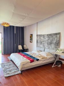 a bedroom with a large bed and a table at 8ເຮືອນພັກ 8Hotel 8号旅馆 in Vientiane