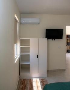 a room with a white cabinet with a tv on it at WaraWara Mini resort in Jan Thiel