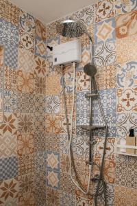 a shower in a bathroom with tiles on the wall at WaraWara Mini resort in Jan Thiel