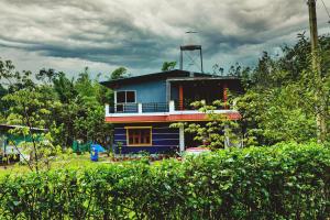 a blue house with a tower on top of it at Rainy Cloud Homestay 3B, Balcony, Home Food in Chikmagalūr