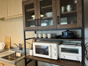 a kitchen with a white microwave and a counter at 江の島ハウス in Fujisawa +16 photos