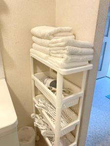 a stack of towels on a towel rack in a bathroom at 江の島ハウス in Fujisawa