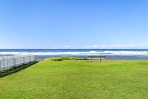 eine Bank am Strand mit dem Meer im Hintergrund in der Unterkunft Apartment 9T in Lennox Head