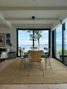 Un comedor con mesa y sillas y una gran ventana. en Villa With Lake View Over Vättern In Vadstena, en Vadstena