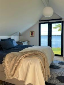 Un dormitorio con una cama con vista al mar. en Villa With Lake View Over Vättern In Vadstena, en Vadstena