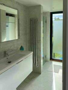 Un baño blanco con lavabo y espejo. en Villa With Lake View Over Vättern In Vadstena, en Vadstena