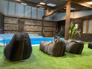 two black bean bags sitting on the grass near a pool at Paradise in the Mountain in Bansko