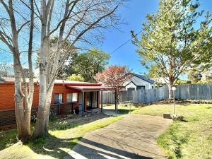 a red brick house with a fence at Snowflakes - Cooma in Cooma