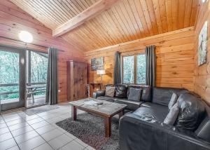 a living room with a leather couch and a table at Quarry Walk Lodges in Cheadle +45 photos