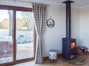 a wood stove in a room with a window at Trelaw - Uk41532 in Ochiltree