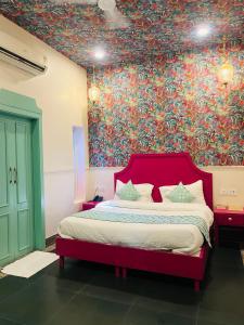 a bedroom with a bed with a colorful wall at Artistik Abode in Varanasi