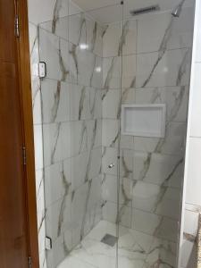 ein Badezimmer mit Dusche und Marmorfliesen in der Unterkunft Flat Comfort Suíte Taguatinga - Sauna, Piscina e Academia - Propriedade Particular 812 in Brasilia