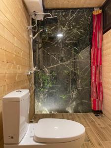 a bathroom with a toilet and a camera on the wall at Son Bá Mười Ecolodge 