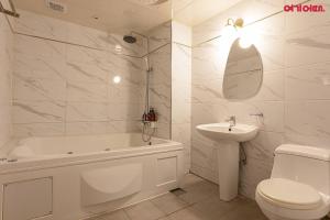 a white bathroom with a sink and a tub and a toilet at S Hotel in Bucheon +22 photos
