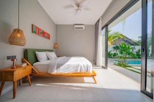 ein Schlafzimmer mit einem Bett und Blick auf einen Pool in der Unterkunft Luxury 4BR Villa Private Pool & Sea Horizon in Kerobokan + 62 Fotos